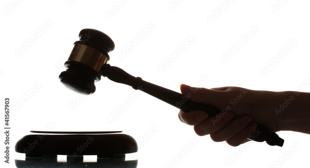 wooden gavel in hand on gray background