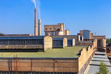 Large factory with smoking chimneys against the blue sky