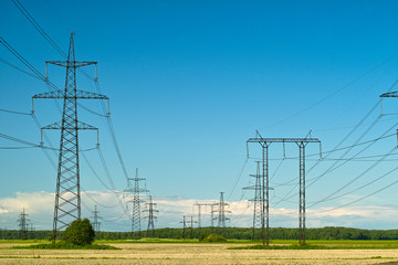 Power line towers and wires, yellow autumn field and sky