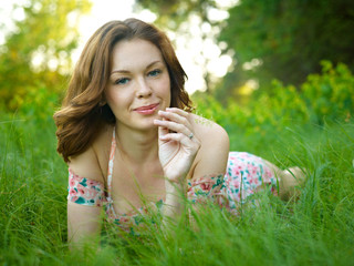 The young woman lies in a green grass