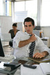 © auremar - Man sat in office adjusting his tie