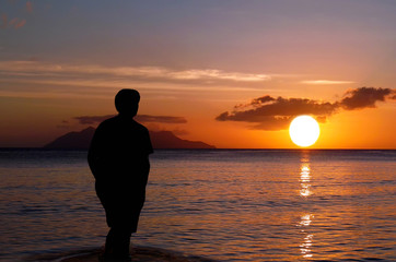 Lone on sunset . Man on paradise sunset beach.