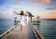Sexy happy woman in white clothes standing on a jetty (Maldives)