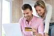 © goodluz - Couple using credit card to shop online