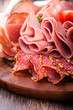 Sliced cold cuts on wooden chopping board