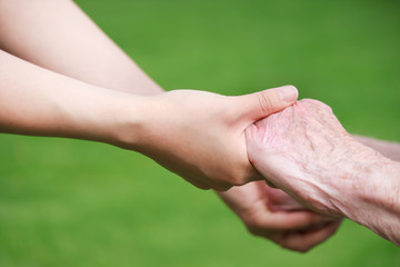 Wall Mural - Senior and Young Women Holding Hands