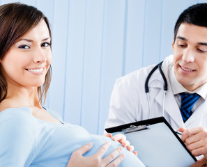 Doctor and pregnant woman with prescription at office