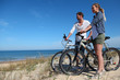 © goodluz - Couple with bicycles looking at the ocean