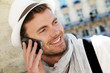 © goodluz - Smiling trendy guy talking on the phone in town