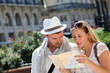 © goodluz - Couple of tourists looking at city tour map