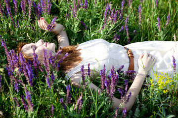 Wall Mural - Young fashion girl lying down at green grass.