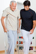 © Tyler Olson - Trainer Helping Senior Man To Walk