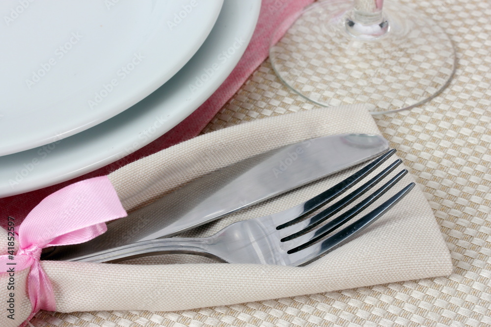 Table setting with fork, knife, plates, and napkin