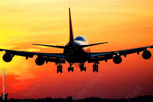 Fototapeta na wymiar Plane landing by sunrise