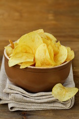 Wall Mural - potato chips in ceramic bowl on a wooden table