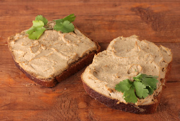 Fresh pate on bread on wooden table