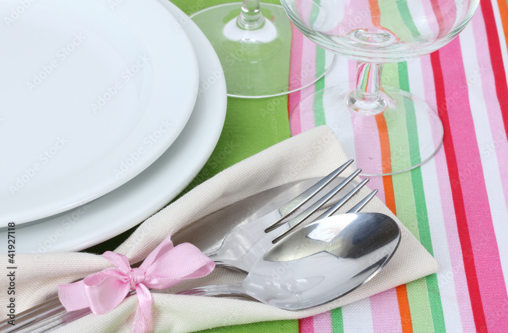 Table setting with fork, spoon, knife, plates, and napkin