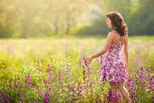 Beautiful Young Woman In Purple Flowers Outdoors