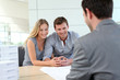 © goodluz - Couple in real-estate agency talking to construction planner