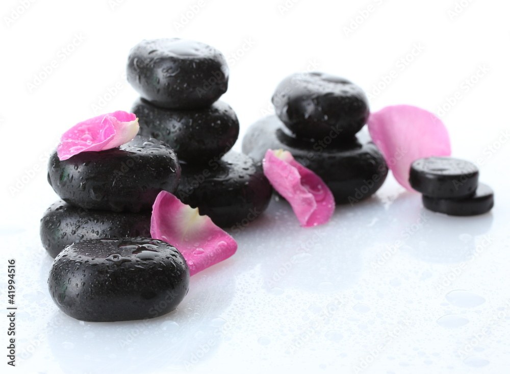 Spa stones with drops and rose petals isolated on white