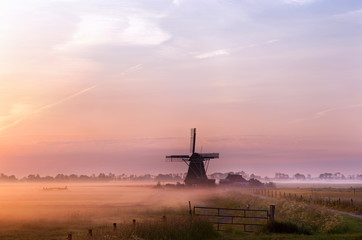 Fototapete - Dutch windmill in fog in the early morning