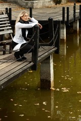 Sticker - Attractive girl squatting by lake in park