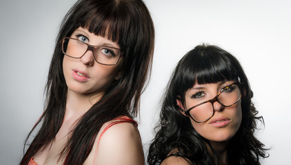 Two pretty girls with crooked eyeglasses