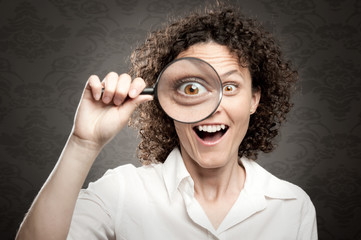 woman looking through magnifying glass