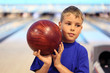 © Pavel Losevsky - thinking boy dressed in T-shirt holds ball in bowling club