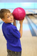 © Pavel Losevsky - Smiling boy dressed in blue T-shirt holds ball in bowling club