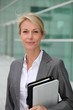 © goodluz - Mature businesswoman standing in front of modern building