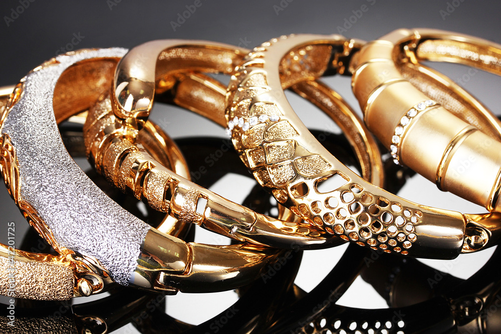 Beautiful golden bracelets on grey background