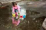 Fototapeta  - girl playing in puddle