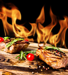 Sticker - Grilled beef steaks with flames on background