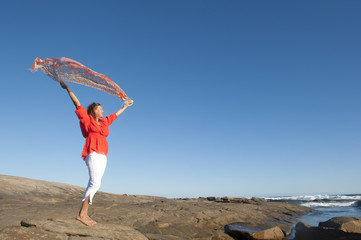 Happy joyful woman with fabric at ocean