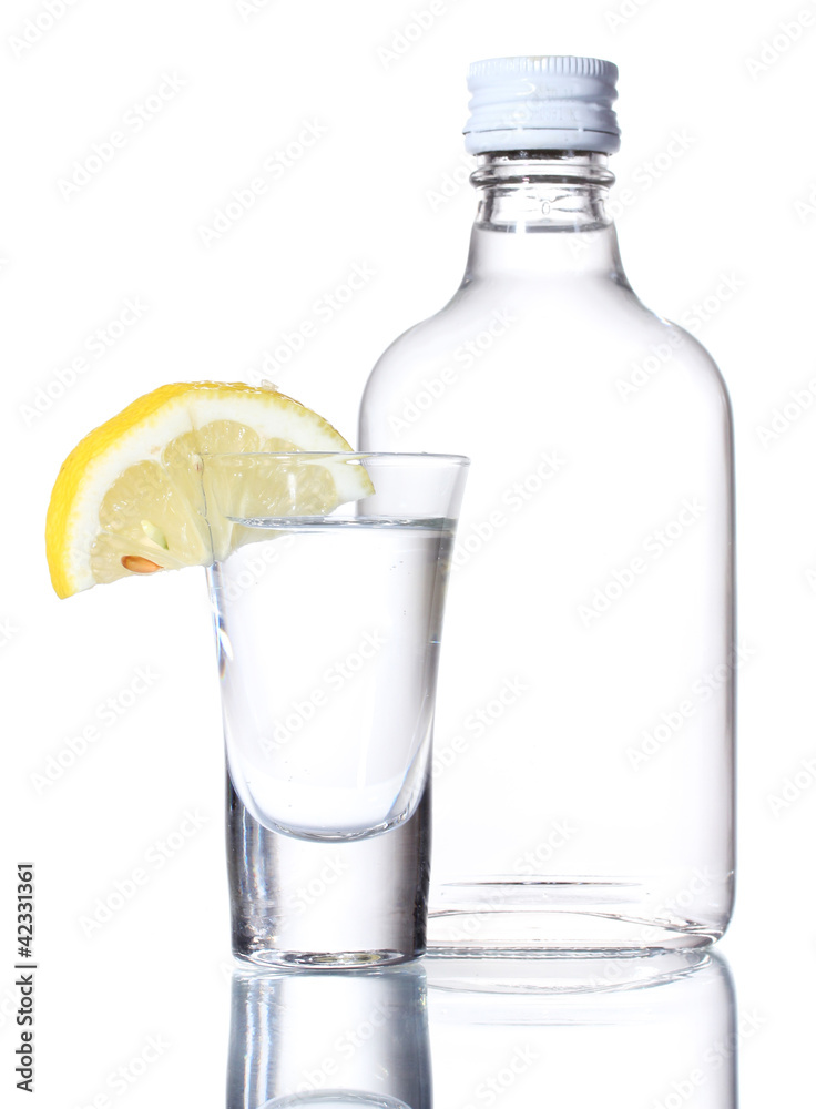 Bottle of vodka and wineglass with lemon isolated on white