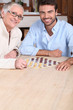 © auremar - Young man playing game with elderly woman