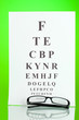 © Africa Studio - Eyesight test chart with glasses on green background close-up