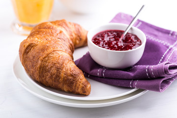 Wall Mural - Croissant and raspberry jam in a small bowl