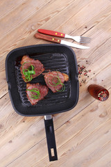 Wall Mural - roast bloody beef fillet steaks on black teflon grill