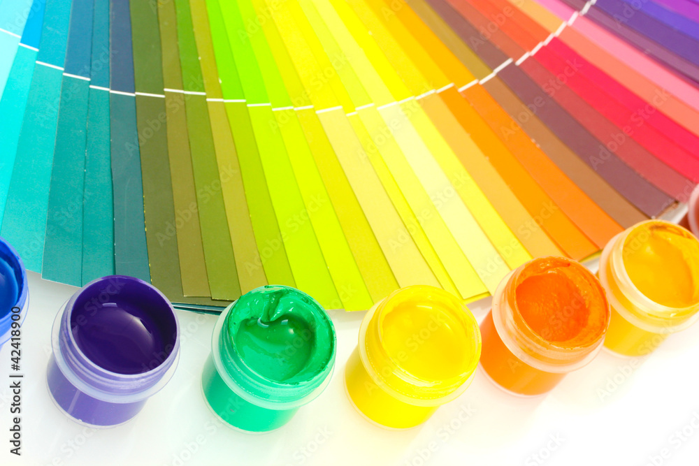 colorful jars with gouache on a palette background close-up