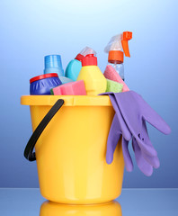 Wall Mural - Bucket with cleaning items on blue background