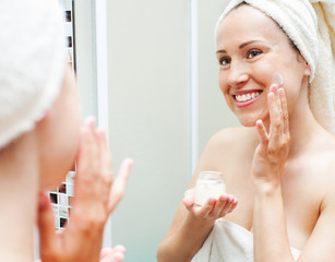 Wall Mural - woman applying cream at the morning