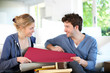 © goodluz - Young couple choosing wallpaper color for new apartment