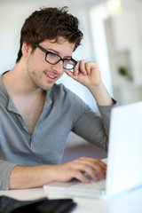 Wall Mural - Young man studying from home