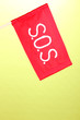 SOS signal written on red cloth on green background