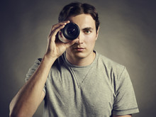 Young Man Photographer Holding A Lens In His Eye