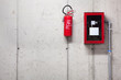 A fire extinguisher and a fire-hose on concrete wall