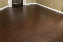 Newly Installed Brown Laminate Flooring And Baseboards In Home