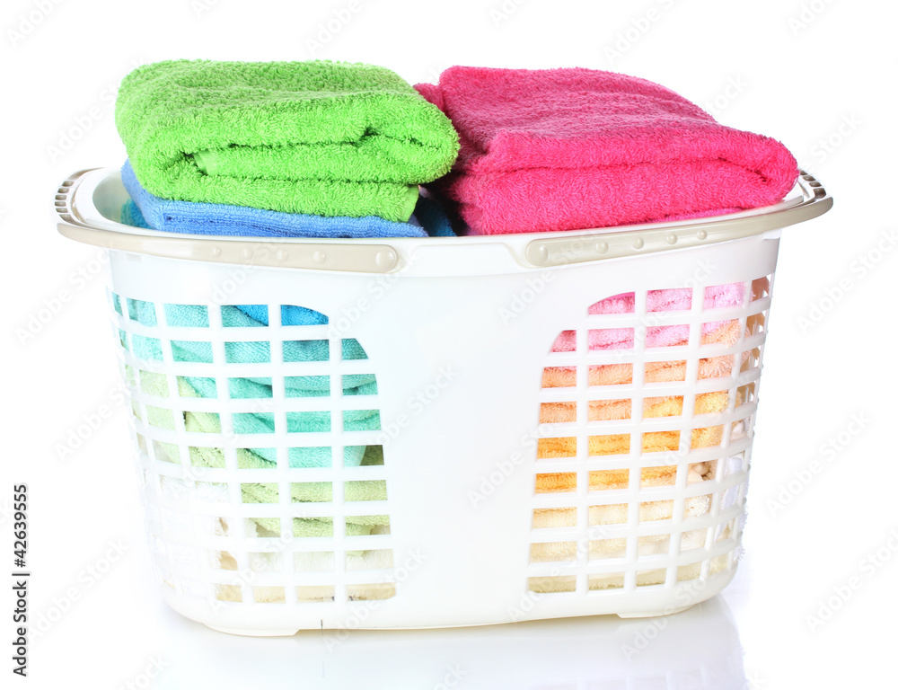 Plastic basket with bright towels isolated on white